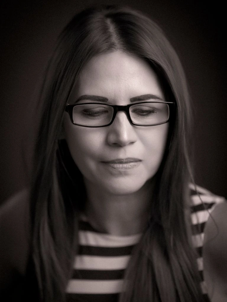 A focused professional seated at a desk in high-contrast monochrome editorial lighting.